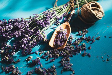 Turkuaz ahşap arka planda, tahta kepçe taze lavanta çiçeği. Aromaterapi, spa, masaj konsepti.