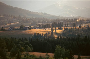 Tihuta, Piatra Fantanele, Bistrita, Romanya 'daki dağ köyü üzerinde sihirli yaz günbatımı
