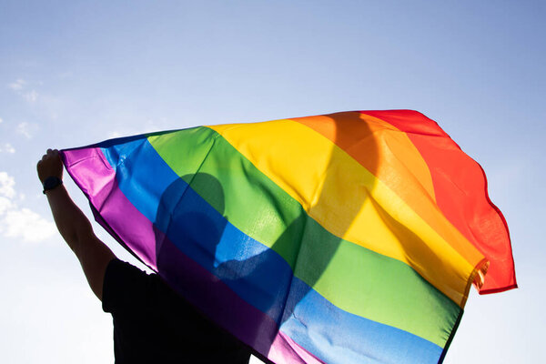 Man holding a Gay Rainbow Flag. Happiness, freedom and love concept for same sex couples