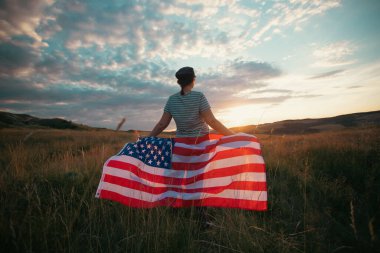 Amerikan bayrağı tutan genç bir kadın. Bağımsızlık Günü ya da Amerika 'da seyahat. 