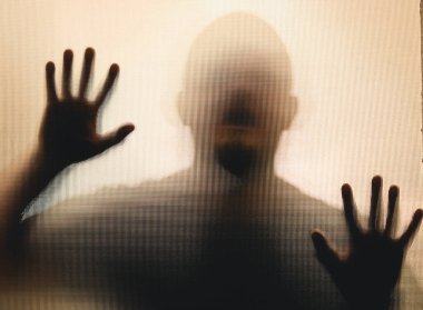 Horror ghost man behind the matte glass. Halloween festival concept.