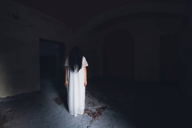 Ghost in abandoned, haunted house. Horror scene of scary spirit of a woman, halloween concept.