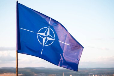 NATO (North Atlantic Treaty Organization) flag waving. NATO is an international military alliance that constitutes a system of collective security
