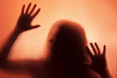 Horror ghost woman behind the matte glass. Halloween festival concept.