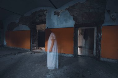Ghost in abandoned, haunted house. Horror scene of scary spirit of a woman, halloween concept.