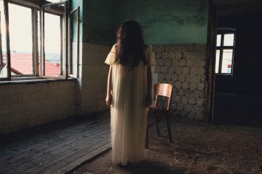 Ghost in abandoned, haunted house. Horror scene of scary spirit of a woman, halloween concept.