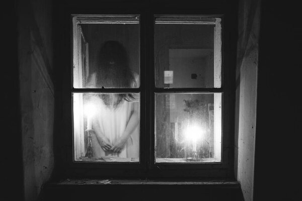 Ghost in abandoned, haunted house. Horror scene of scary spirit of a woman, halloween concept.