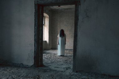 Ghost in abandoned, haunted house. Horror scene of scary spirit of a woman, halloween concept.
