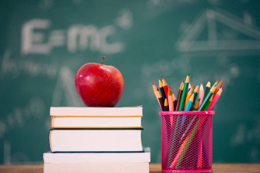 Okul Konseptine geri dönelim. Elma, aksesuarlar ve karatahtaya karşı kitaplar.