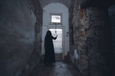 Ghost in abandoned, haunted house. Horror scene of scary spirit of a woman and rope with a noose, halloween concept.