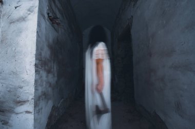 Terk edilmiş, perili bir evde hayalet. Eski balta ve cadılar bayramı konseptini tutan ürkütücü siluet sahnesi.