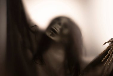 Horror skeleton or grim reaper behind the matte glass. Halloween festival concept.Blurred picture