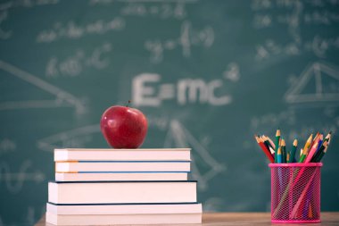 Okul Konseptine geri dönelim. Elma, aksesuarlar ve karatahtaya karşı kitaplar.