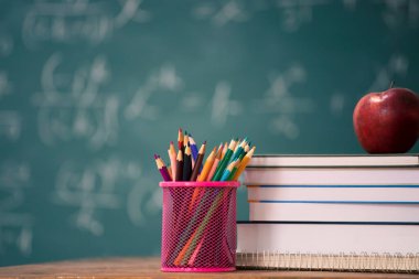 Okul Konseptine geri dönelim. Elma, aksesuarlar ve karatahtaya karşı kitaplar.