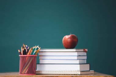 Okul Konseptine geri dönelim. Elma, aksesuarlar ve karatahtaya karşı kitaplar.