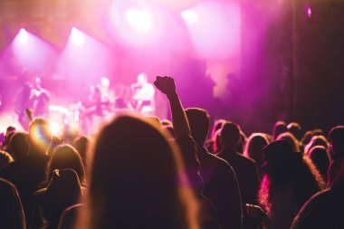 Konserde kalabalık - Parlak renkli sahne ışıkları önünde tezahürat yapan kalabalık