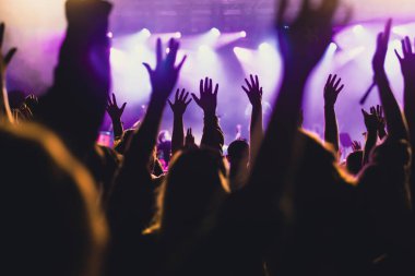 Konserde kalabalık - Parlak renkli sahne ışıkları önünde tezahürat yapan kalabalık