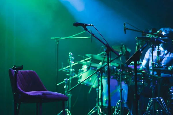 Microphone in colored spotlights and smoke. Concert and theatre scene