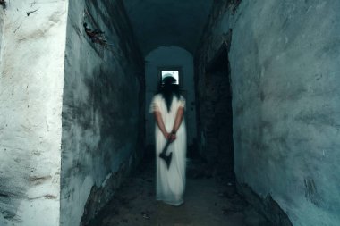 Ghost in abandoned, haunted house. Horror scene of spooky silhouette holding old axe, halloween concept.