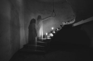 Ghost in abandoned, haunted house. Horror scene of scary spirit of a woman and rope with a noose, halloween concept.