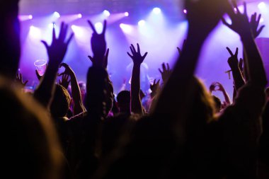 Konserde kalabalık - Parlak renkli sahne ışıkları önünde tezahürat yapan kalabalık
