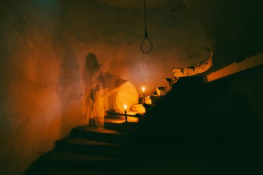 Ghost in abandoned, haunted house. Horror scene of spooky silhouette holding old axe, halloween concept.