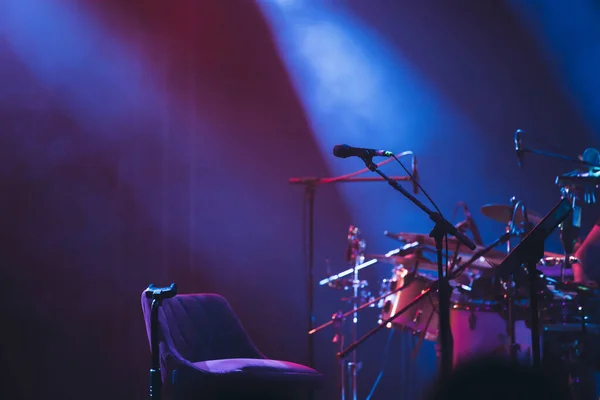 Microphone in colored spotlights and smoke. Concert and theatre scene