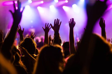 Konserde kalabalık - Parlak renkli sahne ışıkları önünde tezahürat yapan kalabalık