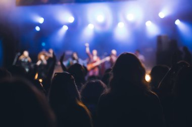 Konserde kalabalık - Parlak renkli sahne ışıkları önünde tezahürat yapan kalabalık