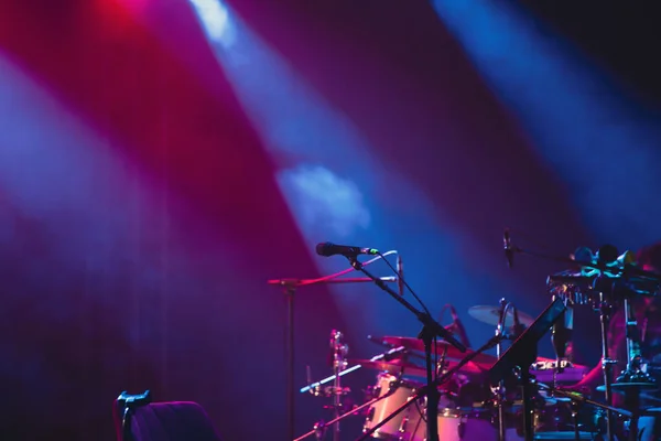 Microphone in colored spotlights and smoke. Concert and theatre scene