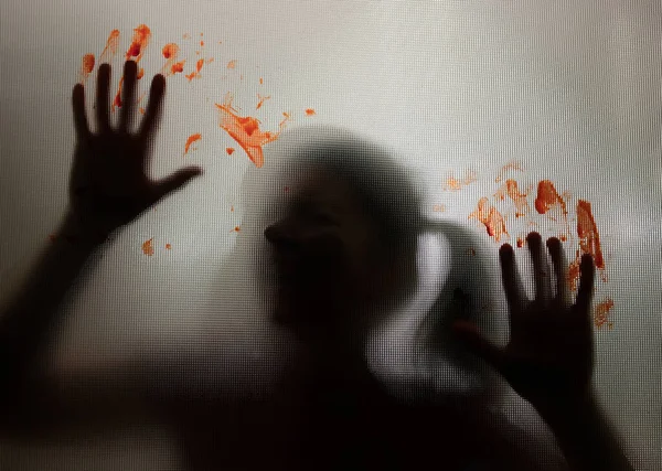 恐怖的鬼女孩在灰蒙蒙的玻璃后面 双手沾满鲜血 万圣节的概念 — 图库照片