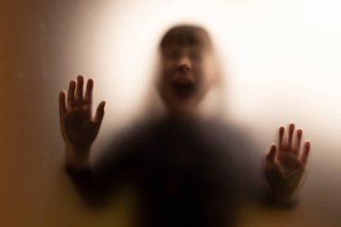 Mat camın arkasında çığlık atan korkunç hayalet kız. Cadılar Bayramı festivali.