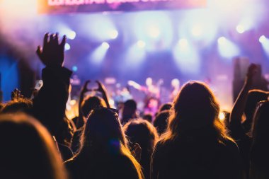 Konserde kalabalık - Parlak renkli sahne ışıkları önünde tezahürat yapan kalabalık