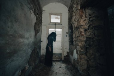 Ghost in abandoned, haunted house. Horror scene of scary spirit of a woman and rope with a noose, halloween concept.