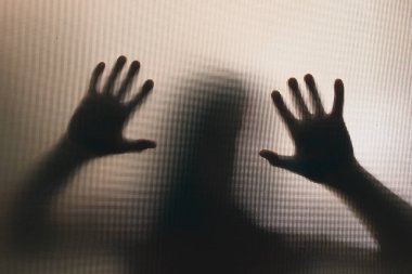 Horror ghost woman behind the matte glass. Halloween festival concept.