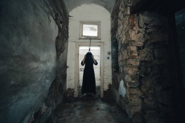 Ghost in abandoned, haunted house. Horror scene of scary spirit of a woman and rope with a noose, halloween concept.