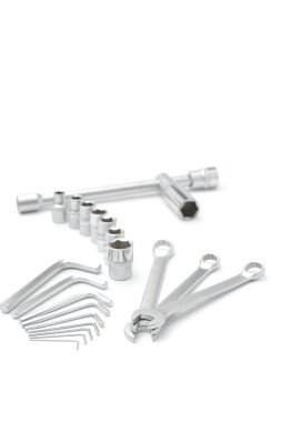 beyaz zemin üzerine metalik somun anahtarları