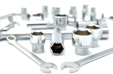 beyaz zemin üzerine metalik somun anahtarları