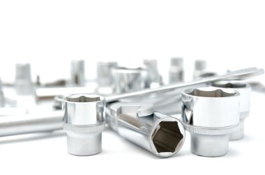 beyaz zemin üzerine metalik somun anahtarları