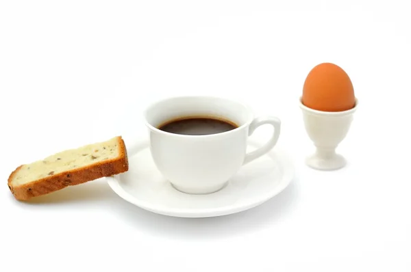Una taza de café negro, pan de desayuno y taza de huevo Imagen De Stock
