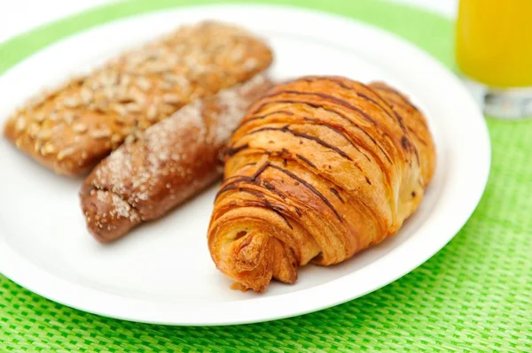 Pão de pequeno-almoço e um copo de sumo de laranja Fotos De Bancos De Imagens Sem Royalties