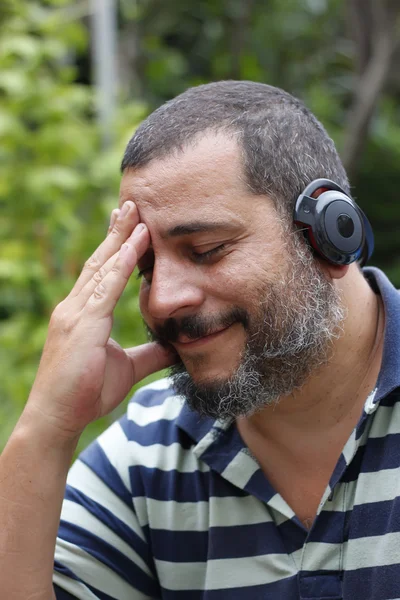 Homem maduro ouvir música com fones de ouvido bluetooth — Fotografia de Stock