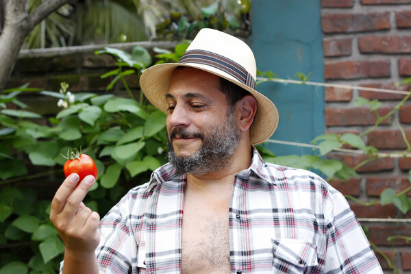 Man looking at his tomato