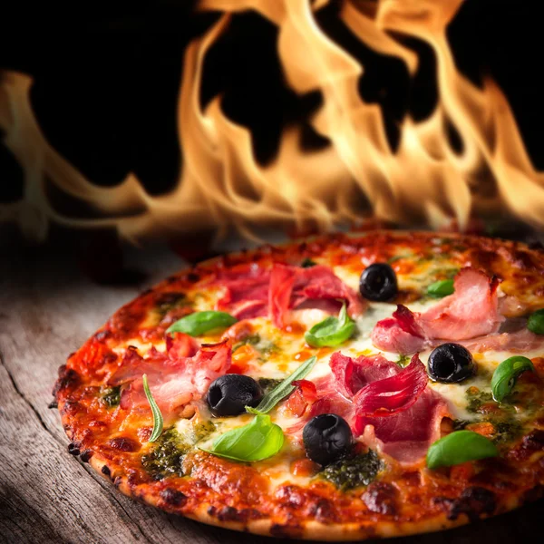 Leckere italienische Pizza mit Flammen — Stockfoto