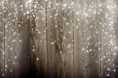Old wooden background with falling snow flakes