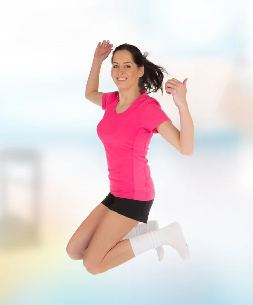 Happy young fitness woman jumping — Stock Photo, Image