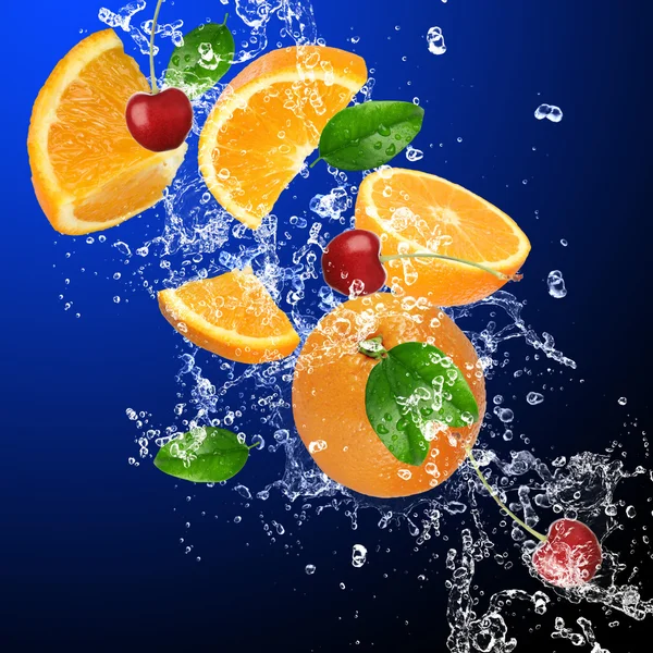 Pomarancze i wiśnie w plusk wody — Zdjęcie stockowe