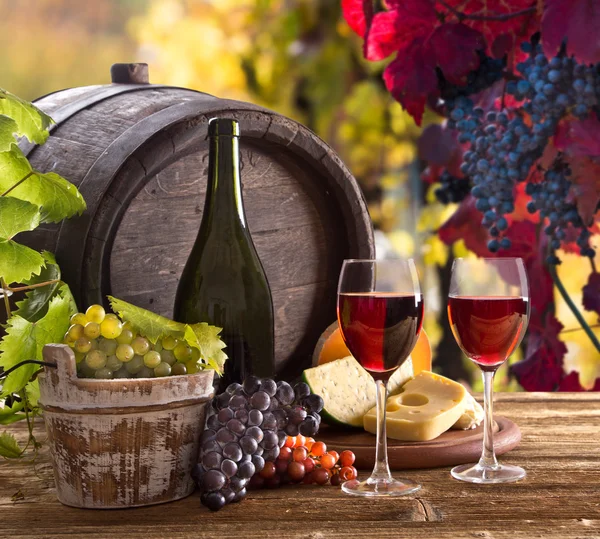 Fles wijn en bril op houten tafel — Stockfoto