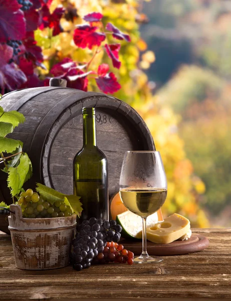 Fles wijn en bril op houten tafel — Stockfoto