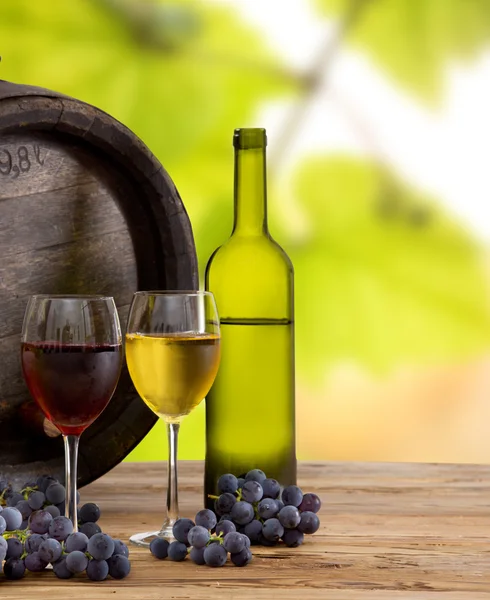Fles wijn en bril op houten tafel — Stockfoto
